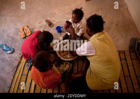 Aissa, 8, Fata, 10, und Fadimata, 15 teilen sich das Essen, das ihre Mutter Fatima vor der Schulzeit in Bamako, Mali, am 1. Februar 2013 zubereitet hat. Fatima floh im April 2012 nach der Ankunft der Islamisten aus ihrer Heimatstadt Timbuktu. Ihr pensionierter Ehemann, Major Sagui, blieb in Timbuktu. Nach Angaben von Amnesty International sind 250,000 Menschen aus Mali geflohen, als islamische Kämpfer mit Verbindungen zu Al-Qaida den nördlichen Teil des Landes unter Kontrolle nahmen. Foto von Julien Tack/ABACAPRESS.COM Stockfoto