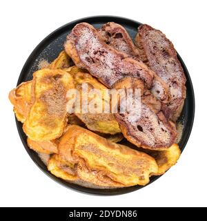 Traditionelle Weihnachten Rabanadas, spanische Torrijas oder französisch Toasts Nahaufnahme von oben auf schwarzer Keramik Platte isoliert auf weißem Hintergrund. Stockfoto