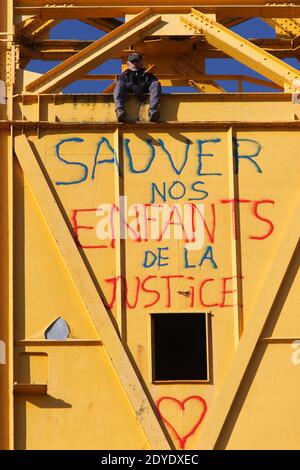 Serge Charnay steht auf einem riesigen Kran, der am 17. Februar 2013 in Nantes am dritten Tag eines Protestes für seine Rechte als Vater stillsteht. Er malt die Botschaft "rette Kinder vor der Gerechtigkeit". Foto von Laetitia Notarianni/ABACAPRESS.COM Stockfoto