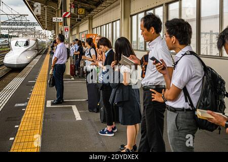 Shinkansen-Plattform in Kakegawa, Japan. Die Shinkansen halten mit den Türen genau an den auf der Plattform markierten Stellen an. In Japan gibt es keine Menschenverdrängung. Sie fügen sich den Warteschlangen, die sich bilden, bei Stockfoto