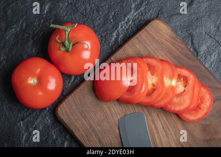 Nahaufnahme von frisch gepflückten, saftigen Tomaten auf dunklem Steinhintergrund Stockfoto