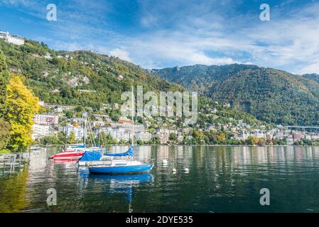 Zwei Boote, die am Ufer eines Alpensees mit Gebäuden im Hintergrund festgemacht sind. Montreux, Genfersee in der Schweiz Stockfoto