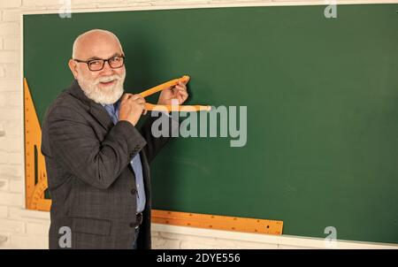 Lehrer des Obermannes verwenden Kompasswerkzeug. Bärtiger Tutor zeichnet mit Kompass auf der Tafel. Zurück zur Schule. Mathematische Grafikwerkzeuge Konzept. Für Wissen. Mathe für gute Ergebnisse untersuchen. Speicherplatz kopieren. Stockfoto