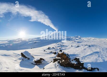 Kamtschatka Halbinsel, Winter Berglandschaft, schöne Panoramablick auf Eruption aktiven Vulkan bei klarem sonnigen Wetter mit blauem Himmel Stockfoto