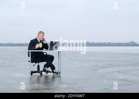 Ältere graubärtige Geschäftsmann in Anzug, lächelnd, während im Gespräch auf dem Smartphone Stockfoto