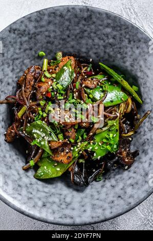 Soba Nudeln mit Rindfleisch, Karotten, Zwiebeln und Paprika. Wok unter Rühren braten. Grauer Hintergrund. Draufsicht Stockfoto