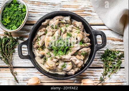 Rind Stroganoff mit Pilzen und frischer Petersilie. Weißer Hintergrund. Draufsicht Stockfoto