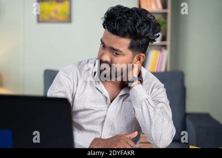 Der junge Mann wurde enttäuscht, indem er Post vom Laptop las - Konzept der schlechten Nachrichten, Kündigung des Arbeitsplatzes, Geschäftsfrist oder Räumungsbefehl. Stockfoto