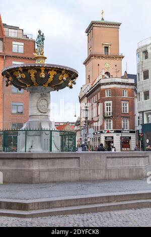 Kopenhagen, Dänemark - 9. Dezember 2017: Blick auf die Straße mit dem Caritas-Brunnen von Statius Otto und der Kirche unserer Lieben Frau auf einem Hintergrund, gewöhnliche Menschen Stockfoto