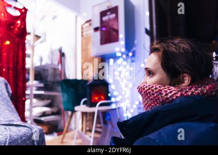 Schöne Frau mit Blick auf ein Schaufenster an einem kalten Wintertag. Concept Shopping in der Stadt Stockfoto