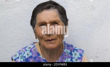 Authentisches Porträt einer 80 Jahre alten Dame gemischter Ethnie. Faltiges Gesicht einer älteren Frau mit besorgter Emotion und verdächtigem Blick. Ältere Menschen Stockfoto