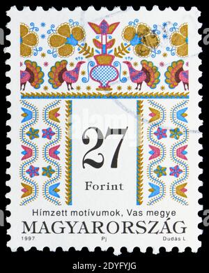 MOSKAU, RUSSLAND - 19. JULI 2019: Die in Ungarn gedruckte Briefmarke zeigt Volksmotive des Komitats Vas, ungarische Volkskunstserie, um 1997 Stockfoto