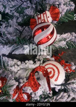 Nahaufnahme rot und weiß Weihnachtsbaum Dekorationen auf ein Schneebedeckter Baum Stockfoto