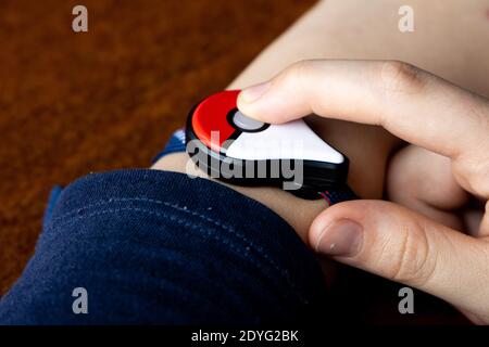 Childs Hand mit neuen japanischen Spiel Pokemon GO plus von der Pokemon Firma Nintendo gemacht. Süchtig beliebte Aktivität bei Kindern und Erwachsenen. Stockfoto