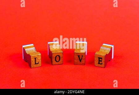 WORTLIEBE aus auf hellrotem Hintergrund, Kopierraum, Holzgummi Briefmarkenretro vintage Buchdruck Fliesen Schrift Nahaufnahme gemacht. Valentinstag Typ Stockfoto