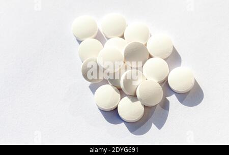 Einfache einfache weiße Pillen Haufen, Medikamente, Tabletten auf weißem Hintergrund gestapelt, Pharmaindustrie, Rezept abstrakte Medikamente medizinische Versorgung Stockfoto