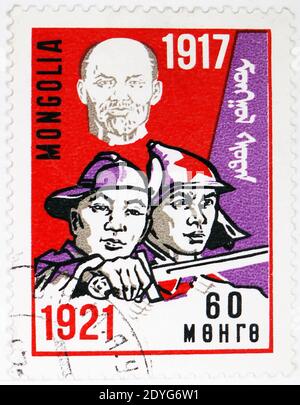 MOSKAU, RUSSLAND - 4. AUGUST 2019: Briefmarke gedruckt in der Mongolei zeigt Lenin und Soldaten, 50. Jahrestag der Oktoberrevolution Serie, um 1 Stockfoto