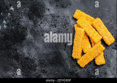 Gefrorenes Brot zerbröselt Fischfinger. Schwarzer Hintergrund. Draufsicht. Speicherplatz kopieren Stockfoto