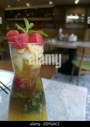 Eine vertikale Aufnahme von Cocktail mit Wassermelone, Melone, Erdbeeren und anderen frischen Früchten im Café Stockfoto