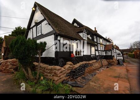 Severn Stoke, Worcestershire, Großbritannien. Dezember 2020. Das Rose and Crown Pub in Severn Stoke in Worcestershire hat Sandsäcke als Hochwasserschutz. Die Kneipe überflutet die meisten Jahre, als die nahe gelegenen Flüsse Severn und Teme ihre Ufer sprengen. Proprieter Andrew Goodall hat vor kurzem die Kneipe übernommen und Tausende für den Hochwasserschutz ausgegeben. Kredit: Peter Lopeman/Alamy Live Nachrichten Stockfoto