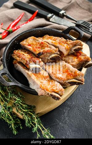 Köstliche würzige marinierte gegrillte Spare Ribs BBQ. Schwarzer Hintergrund. Draufsicht Stockfoto