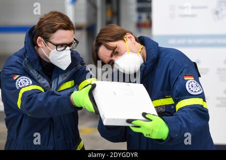 Dasing, Deutschland. Dezember 2020. Mitarbeiter des Technischen Hilfswerks öffnen im Impfzentrum Dasing eine Kiste mit Impffläschchen. In Bayern hat die Verteilung der ersten Impfstoffeinheiten gegen das Corona-Virus an die knapp 100 Impfzentren begonnen. Quelle: Tobias Hase/dpa/Alamy Live News Stockfoto