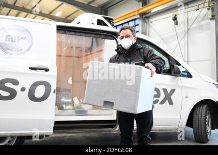 Dasing, Deutschland. Dezember 2020. Ein Lieferant führt eine Schachtel mit den ersten Impffläschchen im Impfzentrum Dasing. In Bayern hat die Verteilung der ersten Impfstoffeinheiten gegen das Corona-Virus an die knapp 100 Impfzentren begonnen. Quelle: Tobias Hase/dpa/Alamy Live News Stockfoto