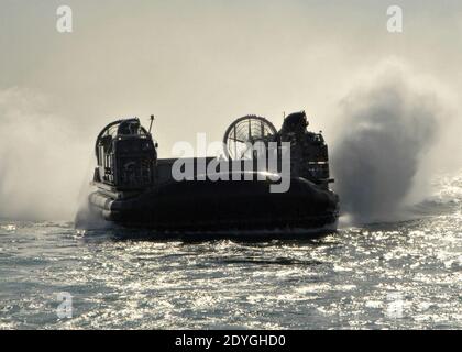 Landing Craft Luftkissen nähert sich USS Carter Hall Stockfoto