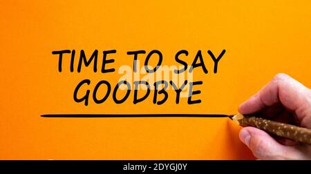 Zeit, Auf Wiedersehen-Symbol zu sagen. Handschriftlich 'Time to Say Auf Wiedersehen', isoliert auf schönem orangefarbenen Hintergrund. Business und Zeit zu sagen Auf Wiedersehen Konzept, Cop Stockfoto