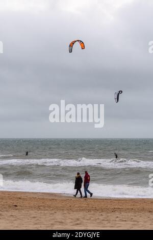 Kitesurfer und Spaziergänger am Strand in Storm Bella, Boscombe, Bournemouth, Dorset, Großbritannien, 26. Dezember 2020, Nachmittagswetter am zweiten Weihnachtsfeiertag. Zunehmende Windstärke an der Südküste Englands mit der Annäherung an Storm Bella, dem zweiten benannten Sturm des Winters. Es ist mit schädlichen Winden von bis zu 80mph m und sintflutartigen Regenfällen zu rechnen. Stockfoto