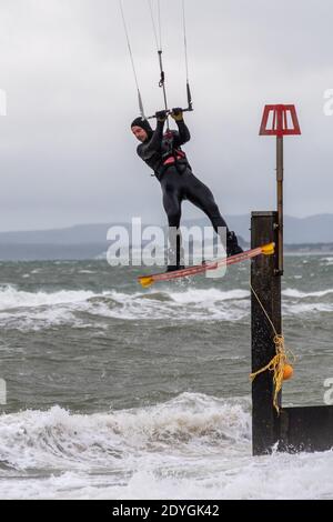 Kiteboarding, Storm Bella, Boscombe, Bournemouth, Dorset, Großbritannien, 26. Dezember 2020, Nachmittagswetter am zweiten Weihnachtsfeiertag. Ein Kiteboarder bekommt einen Auftrieb von starkem Wind an der Südküste Englands mit dem Sturm Bella, dem zweiten benannten Sturm des Winters. Es ist mit schädlichen Winden von bis zu 80mph m und sintflutartigen Regenfällen zu rechnen. Stockfoto