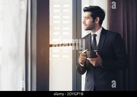 Nachdenklich Geschäftsmann Kaffee trinken, durch das Fenster an der grossen modernen Stadt suchen, in Pause, tief in Gedanken versunken, genießen, warten auf Konferenz Stockfoto