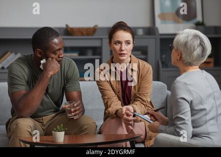 Familienpsychologe arbeitet mit jungen Paar während ihres Besuchs bei Büro Stockfoto