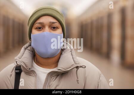 Nahaufnahme der Frau in warmer Kleidung und in Maske suchen Bei der Kamera Stockfoto