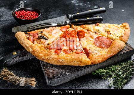 Set von verschiedenen Scheiben Pizza. Schwarzer Hintergrund. Draufsicht Stockfoto