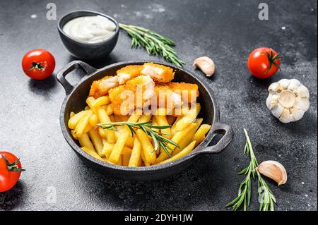 Fish and Chips, britisches Fast Food mit Tatarsauce. Schwarzer Hintergrund. Draufsicht Stockfoto