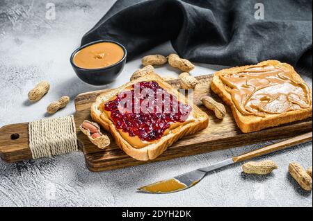 Erdnussbutter und Gelee auf Weißbrot Toasts. Weißer Hintergrund. Draufsicht Stockfoto
