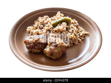 Portion gebratene Kotleta (panierte Hacksteaks), Beilage aus gekochtem Buchweizenbrei auf braunem Teller, auf weißem Hintergrund ausgeschnitten Stockfoto