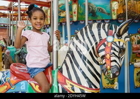 Birmingham Alabama, Zoo Karussell Fahrt Schwarzes Mädchen, Reiten Zebra winken, Stockfoto