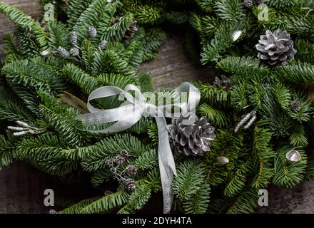 Beauriful grünen Weihnachtskranz auf einer recycelten Holzoberfläche, 45 Grad Winkel, reiche Farben Stockfoto