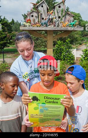 Huntsville Alabama, Botanischer Garten für Kinder im Freien, schwarzer Junge Jungen Führer Lehrer hilft erklären Dinosauriergarten, Stockfoto