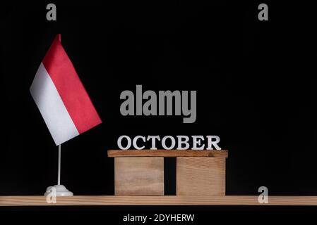Holzkalender Oktober mit polnischer Flagge auf schwarzem Hintergrund. Feiertage in Polen im Oktober Stockfoto