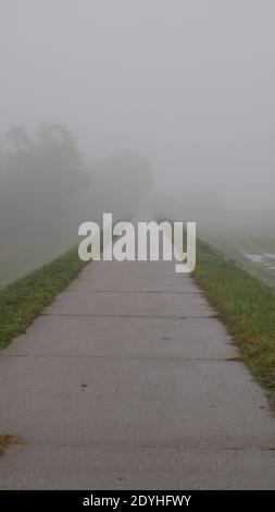 Deich im Nebel gibt ein Gefühl der Einsamkeit während Zeiten der kovid19 Pandemie Stockfoto