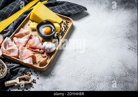 Traditionelle Italienische Pasta Carbonara Zutaten. Speck, Spaghetti, Parmesan und Pecorino Käse, Ei, Knoblauch. Grauer Hintergrund. Draufsicht. Speicherplatz kopieren Stockfoto