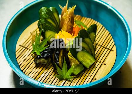 Rakan, ein Kaiseki-Restaurant, das vom Chefkoch Atsuko Kato auf der Izu-Halbinsel in Japan geführt wird. In einer türkisfarbenen Schüssel sind Gurke, Aubergine und Ingwer kunstvoll angeordnet und mit einem Ahornblatt garniert. Stockfoto