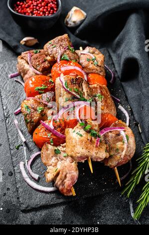Kebab mit Zwiebel und Tomate schälen. Gegrillte Fleischspieße. Schwarzer Hintergrund. Draufsicht Stockfoto