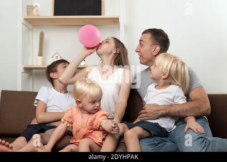 Große Familie zu Hause Vorbereitung auf den Urlaub. Mutter aufgeblasen Ballon, Überraschung Papa. Stockfoto