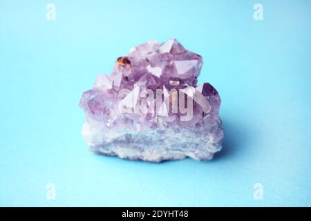 Schöne Druse von natürlichen lila Mineral Amethyst auf einem blauen Hintergrund. Große Kristalle eines Edelsteins. Stockfoto