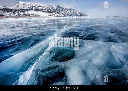 Blick auf schöne Zeichnungen auf dem Eis von Rissen und tiefen Gasblasen auf Oberfläche des Baikal-Sees im Winter, Russland Stockfoto