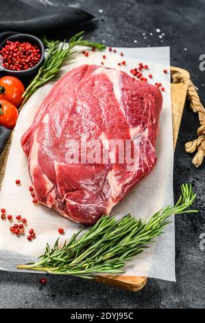 Roh Rundes Rindfleisch auf einem Schneidebrett geschnitten. Schwarzer Hintergrund. Draufsicht Stockfoto